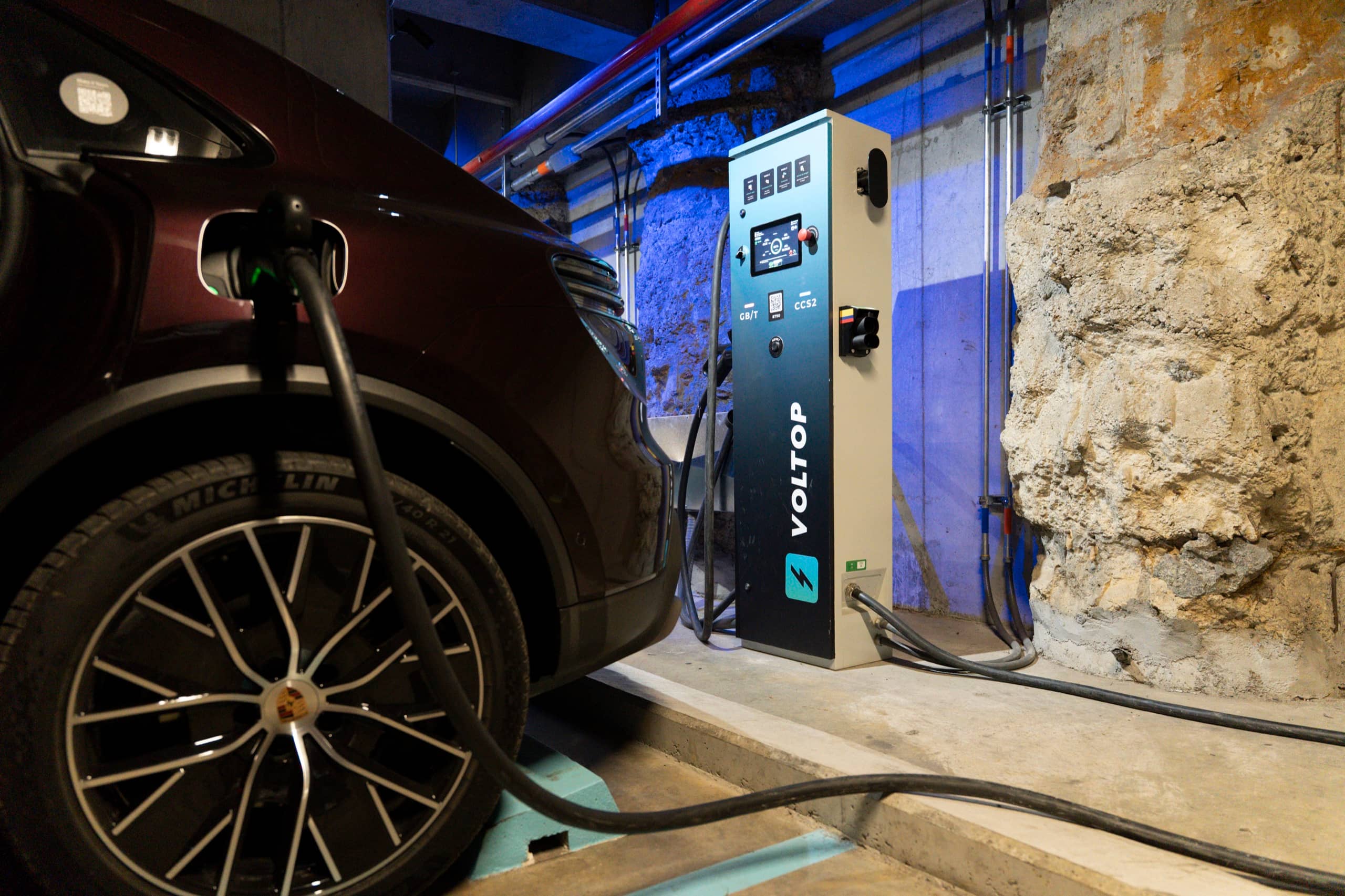 Vehículo eléctrico conectado a un cargador Voltop en un parqueadero cubierto